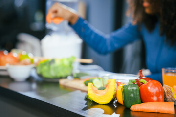 African American woman sitting  table, enjoying a colorful salad orange juice, highlighting the health benefits of five-color fruits vegetables, rich in antioxidants, reducing cancer risks,wellness