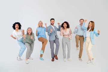 Obraz premium Group of diverse coworkers celebrating success in professional attire against a neutral background