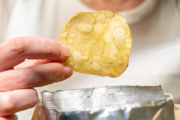 Enjoying a crispy potato chip snack at home during a relaxing afternoon