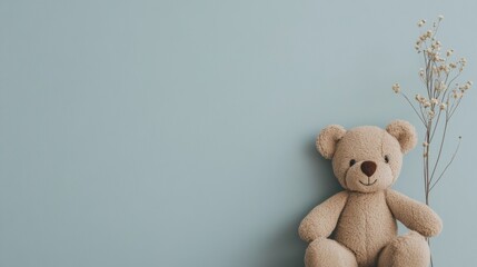 Cute teddy bear and dried flowers on blue background.