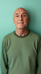 Obraz premium Minimalist portrait of an older man against a vibrant mint green background showcasing warmth and wisdom