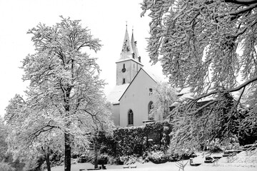 The &ldquo;Oberste Stadtkirche&rdquo; is a Protestant church in Iserlohn (Sauerland). Idyllic black and white winter atmosphere with the double bell towers and the inner-city park landscape in heavy snowfall.