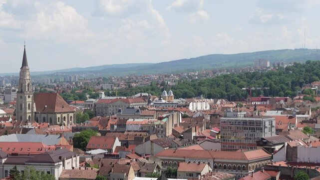 view of Cluj city with Saint Michael Church in the view, and a mountain backdrop under clear sky