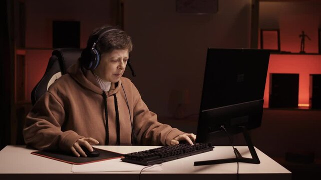 Woman gaming at home. Female gamer playing in online videogame on PC. Professional streamer pro-gamer player angry and smashing her computer keyboard, feeling upset after lose.