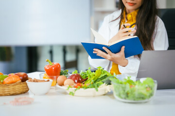Two nutritionists,female and male, work in a hospital, analyzing vegetable and fruit salads,...