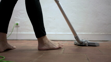 Fototapeta premium Person cleaning home with vacuum cleaner, woman cleans dirty floor corners