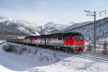 Railway train  against the backdrop of a beautiful snowy winter. Cargo transportation industry