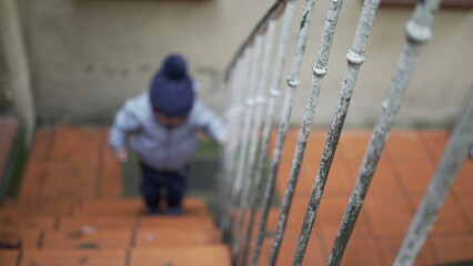 Toddler boy going up the stairs. Baby child goes up the stair during winter season