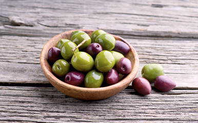 Kalamata olives and green olives on old wooden board