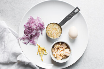 Overhead view of ingredients for making rice chicken congee, mise en place of ingredients for making rice and chicken porridge, ingredients for chinese chicken congee, korean dak juk or japanese okayu