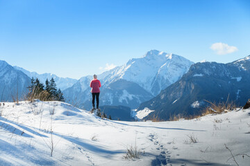 Ein Wanderer blickt vom Winterwanderweg in die verschneiten Berge des Zillertal