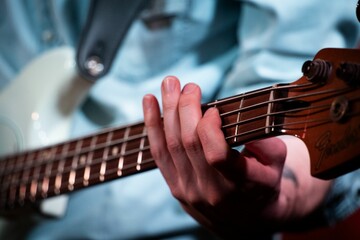 Fototapeta premium A close-up of a person's hand playing a bass guitar