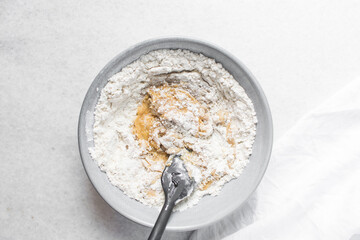 top view of mooncake dough being mixed, Overhead view of homemade mooncake dough in a grey bowl, process of making mooncakes for Lunar New Year and mid-autumn festival