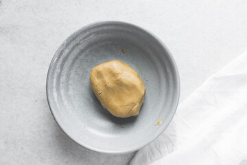 top view of mooncake dough being mixed, Overhead view of homemade mooncake dough in a grey bowl, process of making mooncakes for Lunar New Year and mid-autumn festival