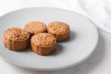 homemade mooncakes on a grey plate, top view of baked mooncakes on a plate, process of making mooncakes for Lunar New Year and mid autumn festival