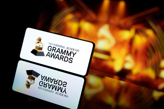 A smartphone displaying the Grammy Awards logo against a blurred awards ceremony background.