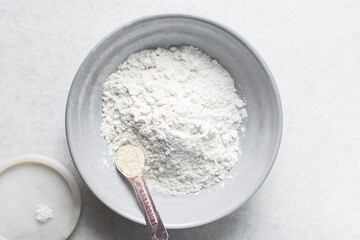 overhead view of All purpose flour in a bowl, top view of baking flour in a ceramic bowl