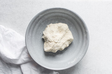 Overhead view of noodles dough in a grey bowl, top view of homemade biang biang noodles, process of making hand pulled noodles