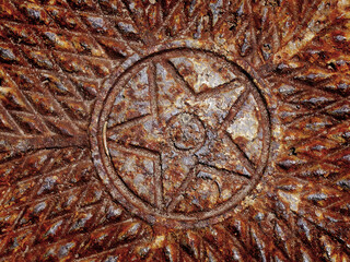 Rusty Star Design on Metal Cover Manhole