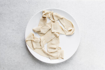 Overhead view of uncooked belt noodles, top view of raw biang biang noodles, process of making biangbiang mian