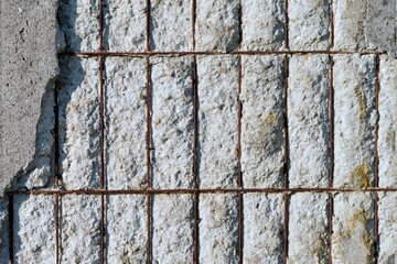 Close-up detail of a ruined concrete wall with exposed irons