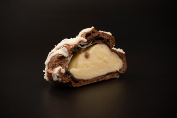 Profiteroles with coconut cream on a black background.