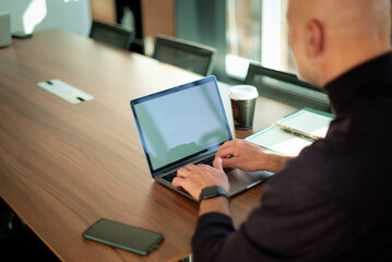 Executive businessman sitting at the office desk and using his laptop