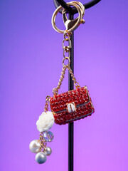 close up of beautiful shiny red  rhinestone handbag keychain on  purple background
