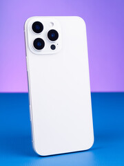 Close-up of modern white  smartphone with three cameras  on purple background
