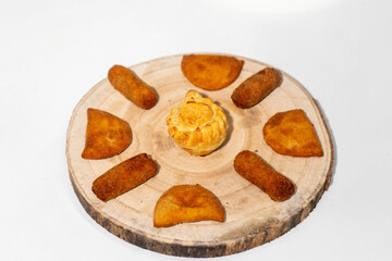 Assorted savory snacks on a rustic wooden board, ready to eat. A delicious variety of appetizers perfect for parties, catering, or food styling concepts.