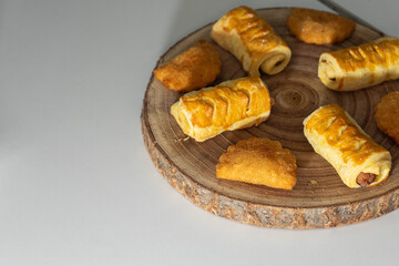 Assorted savory snacks on a rustic wooden board, ready to eat. A delicious variety of appetizers perfect for parties, catering, or food styling concepts.