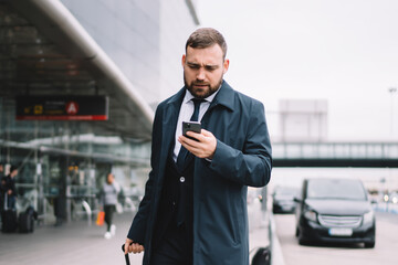 Stylish man with suitcase waiting for taxi