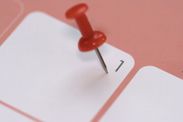 Calendar entry: Number 1 pinned with a red push pin or thumbtack, symbolizing the “Save the Date” concept.