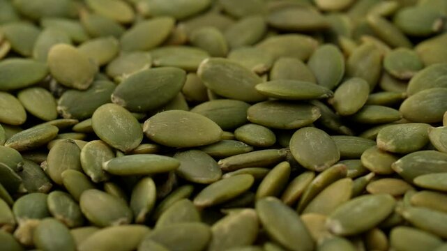Macro video of pumpkin seeds on rotating disc. Close up of bunch of pumpkin seeds.