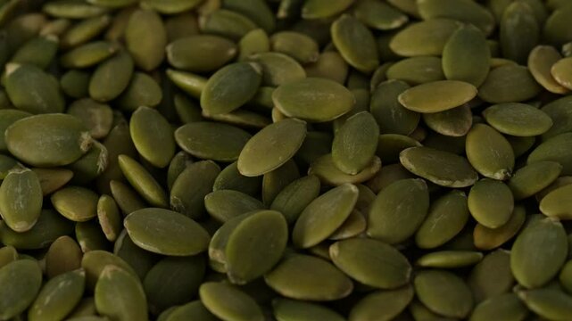 Macro video of pumpkin seeds on rotating disc. Close up of bunch of pumpkin seeds.