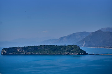 Serene blue water with a rocky island in Cosenza, Calabria, Ital