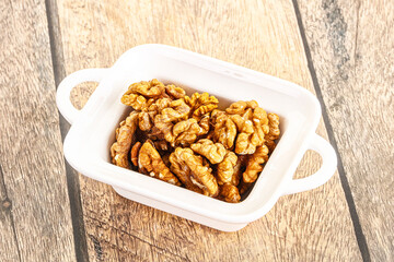 Cracked unshelled walnut in the bowl