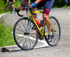 Fototapeta premium legs of cyclist pedaling energetically on the yellow racing bicycle during the race