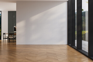 Spacious empty room with wooden herringbone flooring, large floor-to-ceiling windows, and blank...