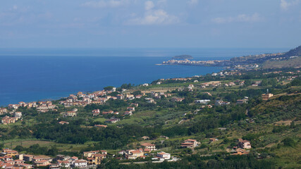 Obraz premium Scenic coastal town with green hills and blue sea