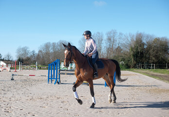 beautiful young woman riding her young mare outdoors