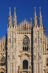 Fototapeta premium facade of Milan Cathedral in northern Italy, a typical example of Gothic religious architecture and the golden statue of the Madonna