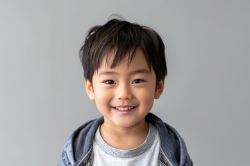 Young Asian boys in relaxed, casual clothing stand against a plain white background, showcasing their joyful innocence and individual styles.