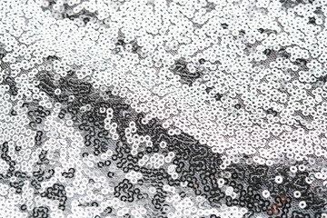 Abstract festive fabric texture with silver sequins.