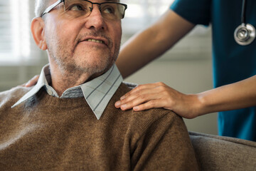 Nurse or doctor supports an elderly man during his recovery and gives encouragement to the elderly....