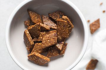 Overhead view of groundnut cake on a white plate, top view of nkatie cake or peanut cake on a plate, candy bar made with roasted peanuts and sugar