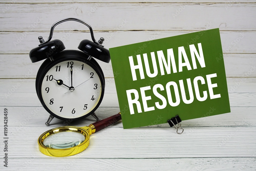Poster human resouce text message on paper card with alarm clcok and magnifying glass on wooden background
