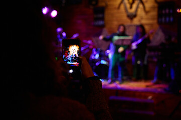 Crowd captures heavy metal band performance at local venue during energetic night