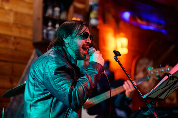 Vocalist performs passionately at a heavy metal concert in an intimate venue