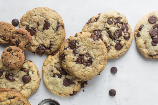 Overhead view of chocolate chip cookies on a cooling rack, top view of homemade chocolate chip cookies on a white background